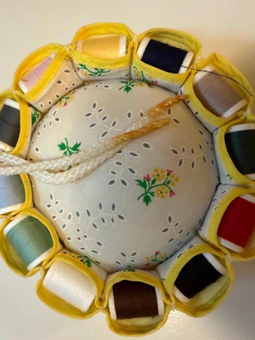 This vintage thread holder and pin cushion for 2 is a round-shaped collectible i